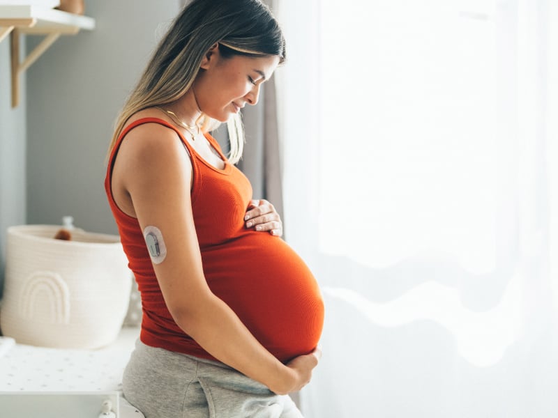 Pregnant woman wearing a glucose monitor