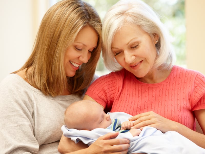 Mother and grandmother hold a newborn child